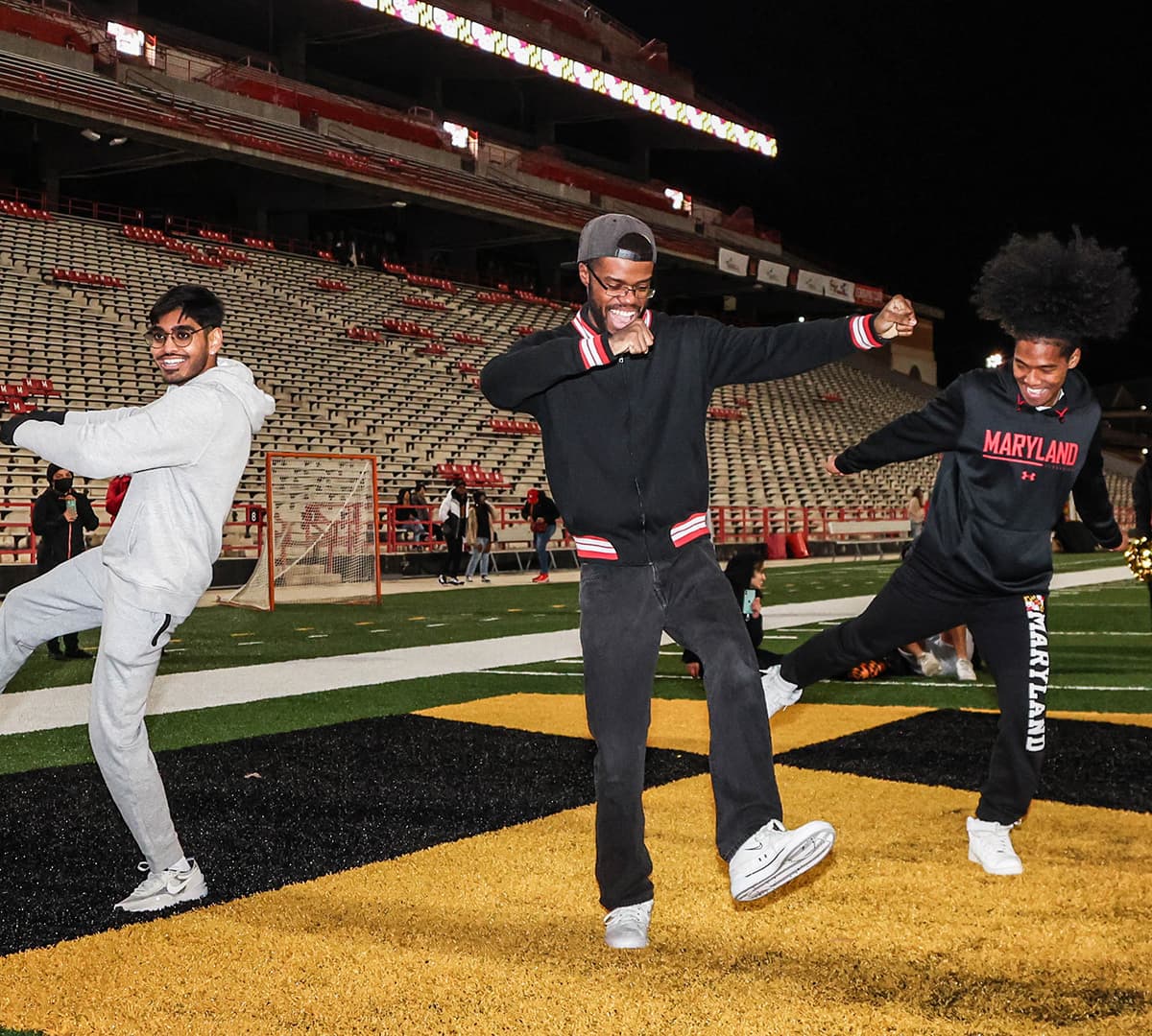 A group of three students dance in the endzone at the Tuesday Night Lights event at SECU Stadium.
