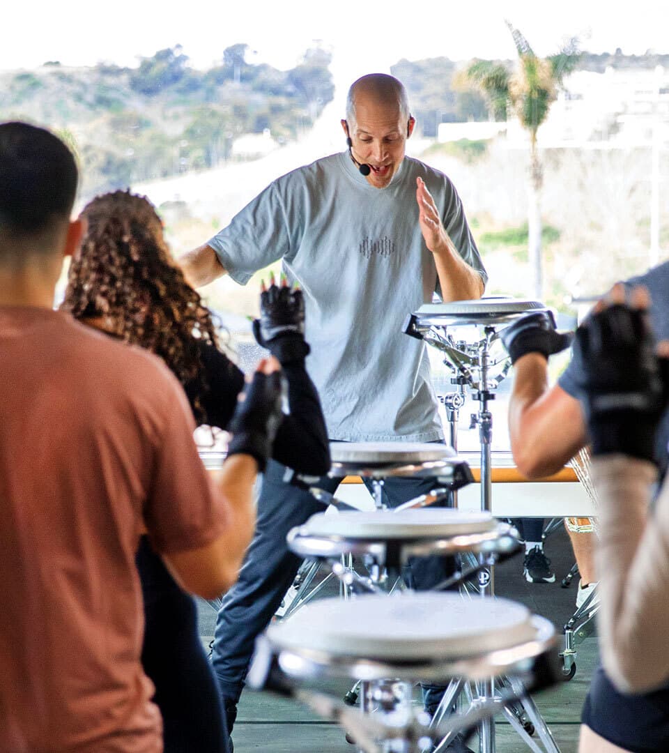 man leads class beating drum