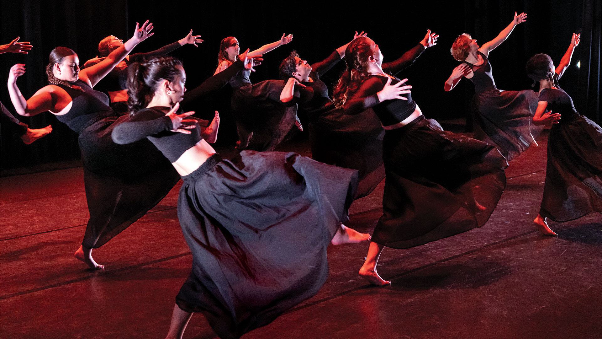 group of students dressed in black dance on stage
