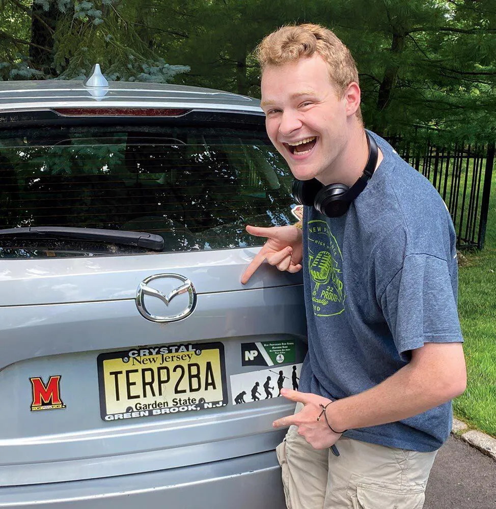 man points to "TERP2BA" license plate on back of car