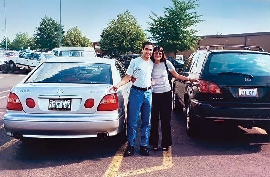 Man points to "TERP MAN" license plate and woman points to "CAL GAL" plate