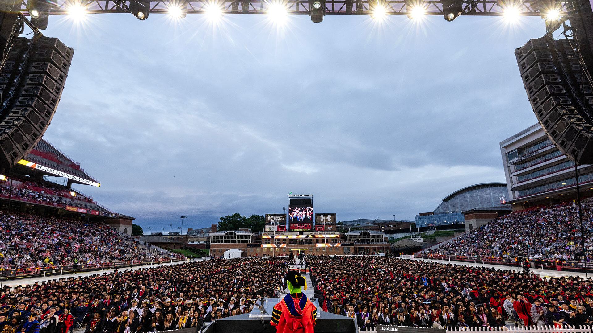 view from behind Kermit the Frog as he addresses graduates at UMD Commencement at SECU Stadium