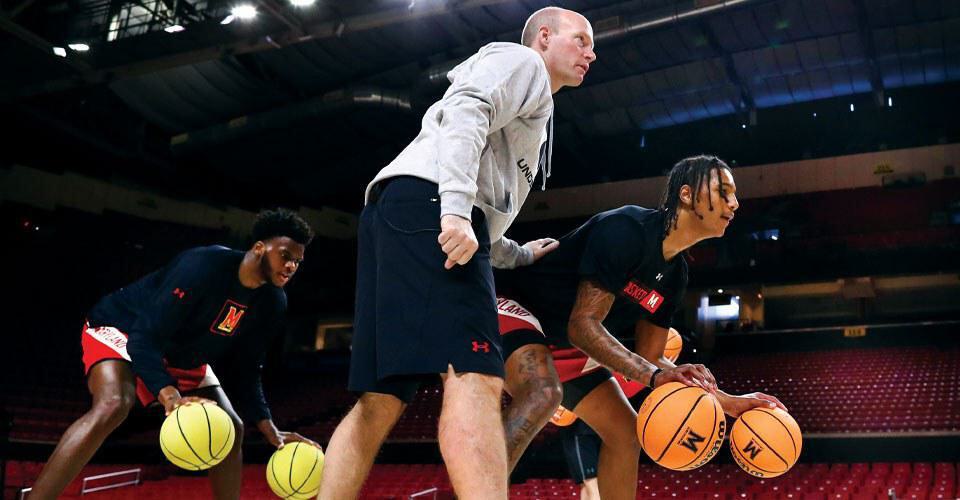 Kevin Willard guides Julian Reese through a drill