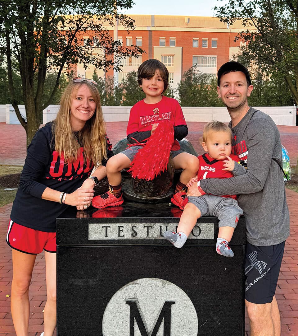 couple and two kids wearing Maryland gear at Testudo statue