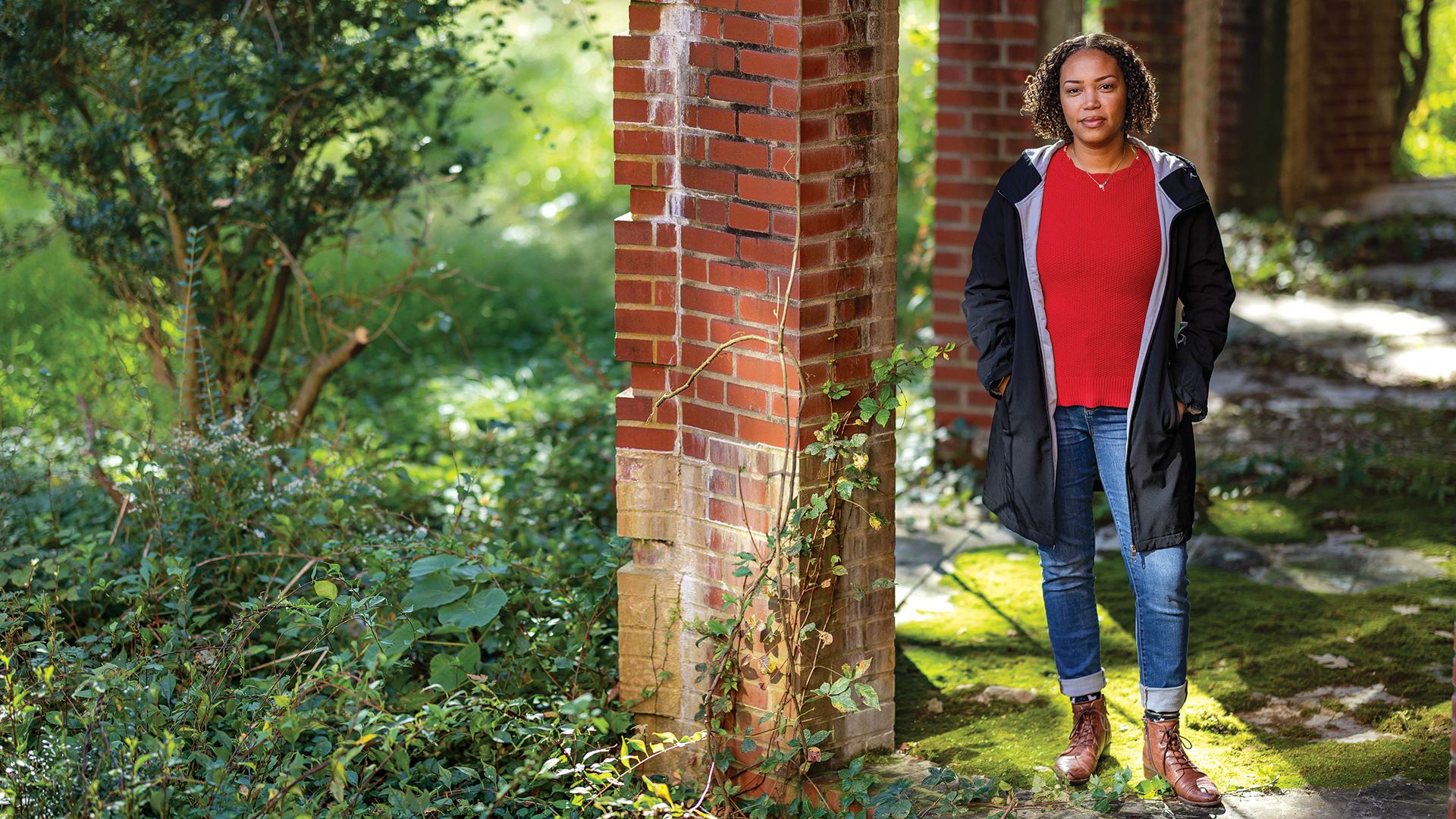 Joi Howard poses by brick columns and greenery