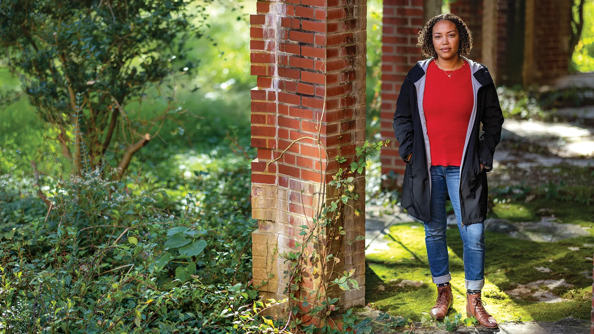 Joi Howard poses by brick columns and greenery