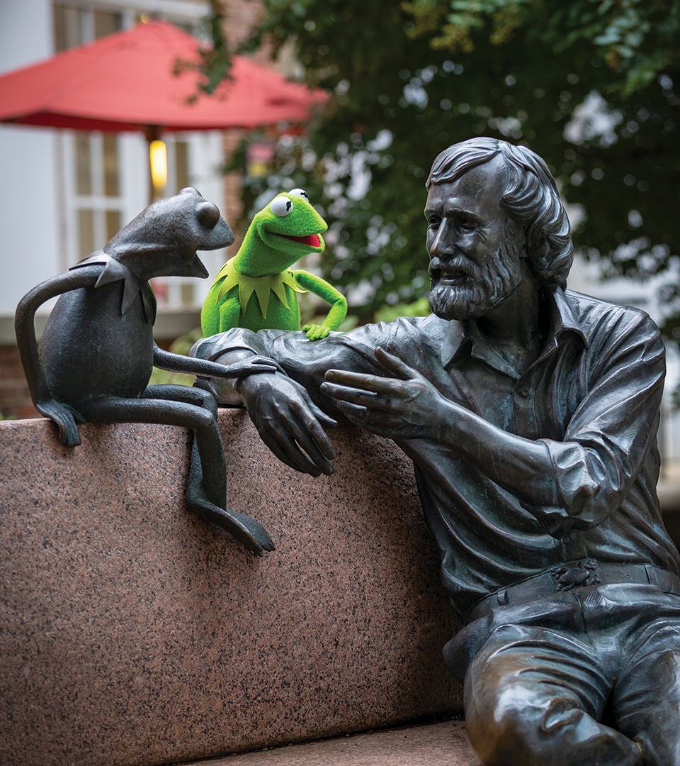 Kermit sits with statue of himself and Jim Henson on UMD campus
