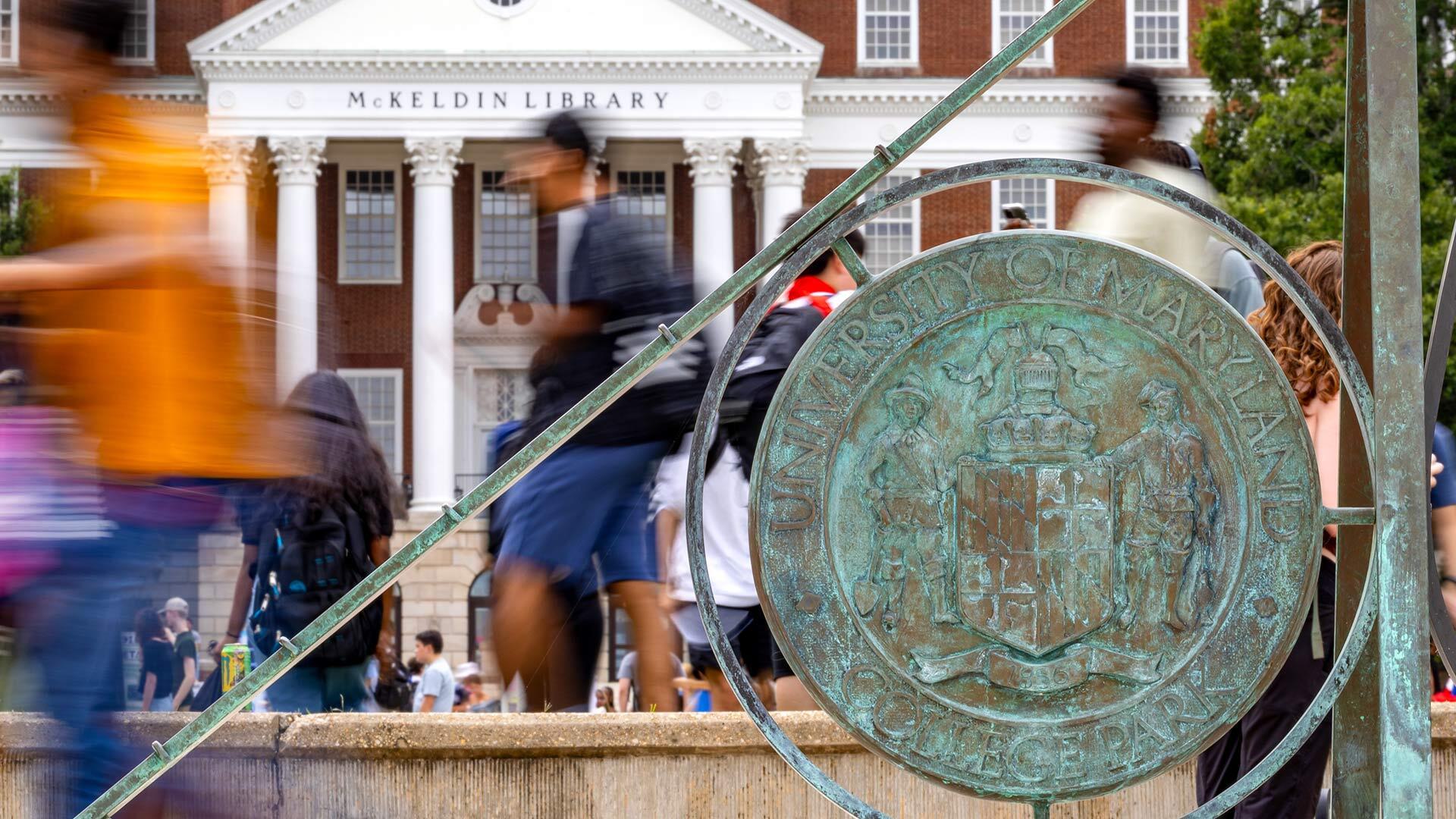 students walk past the sundial on McKeldin Mall