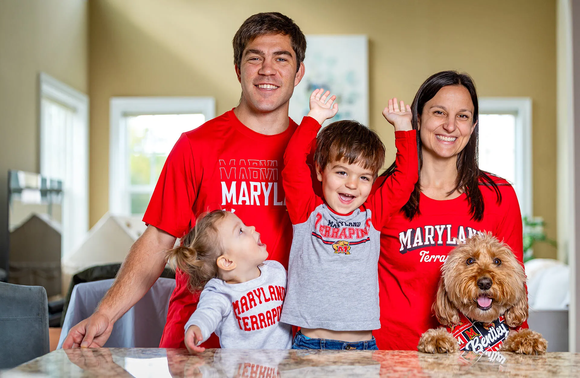 Couple with two kids and goldendoodle in Maryland gear