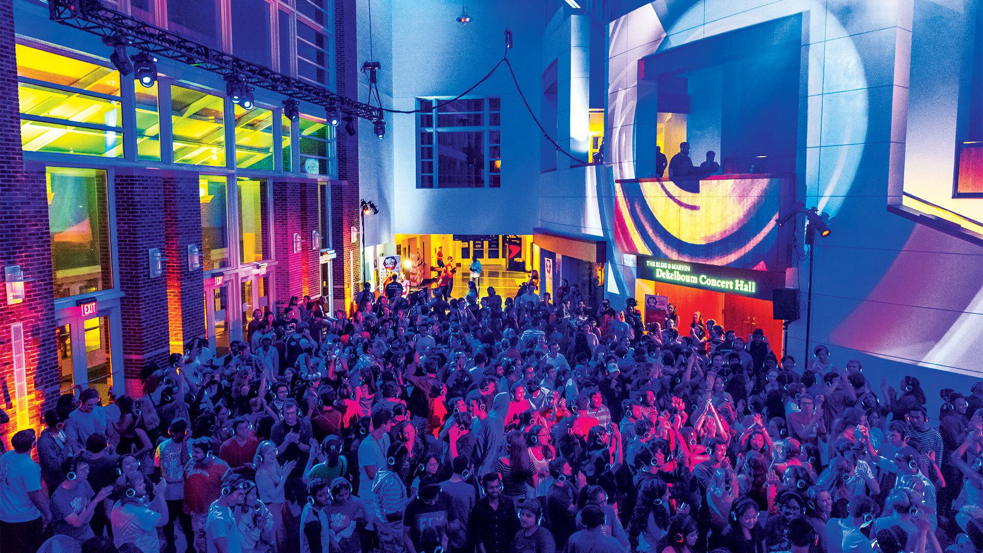 crowd of students dances while wearing headphones