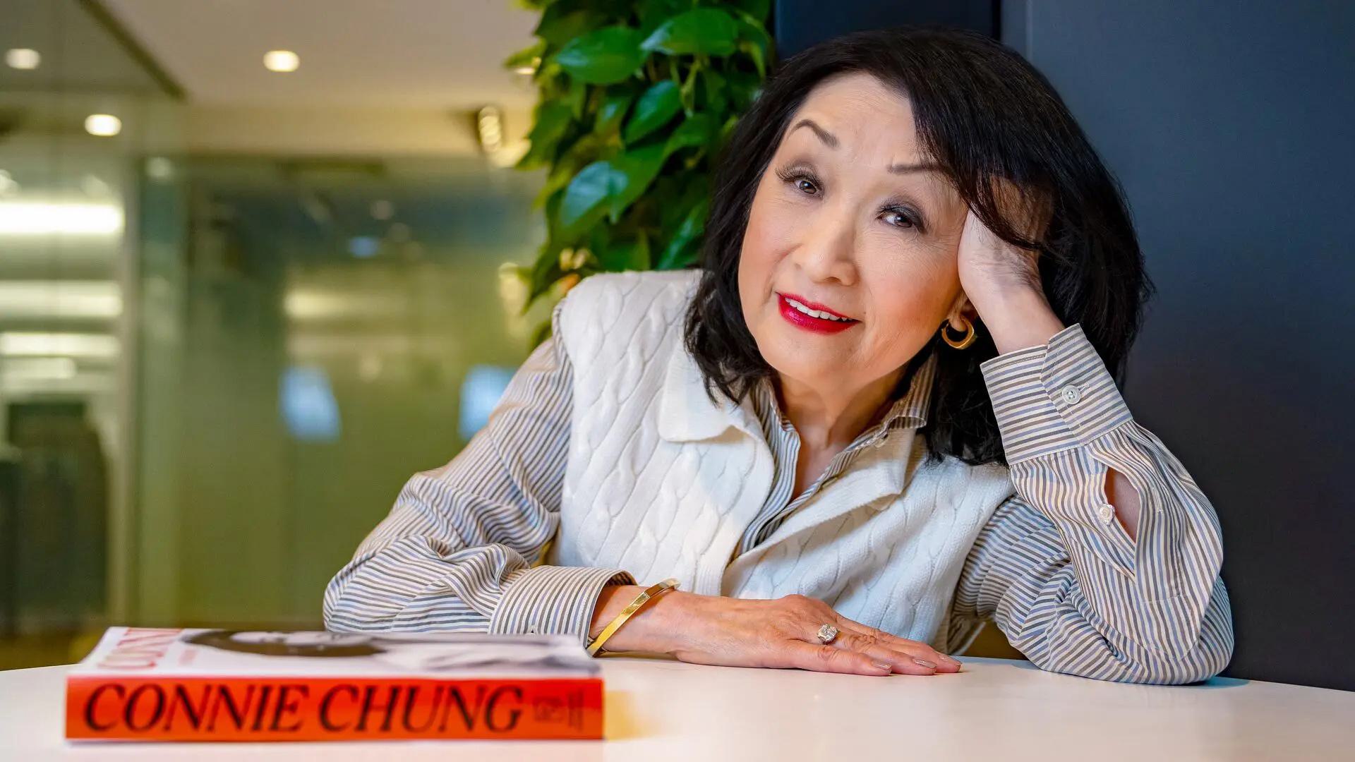 Connie Chung sitting at a table with her book in front of her