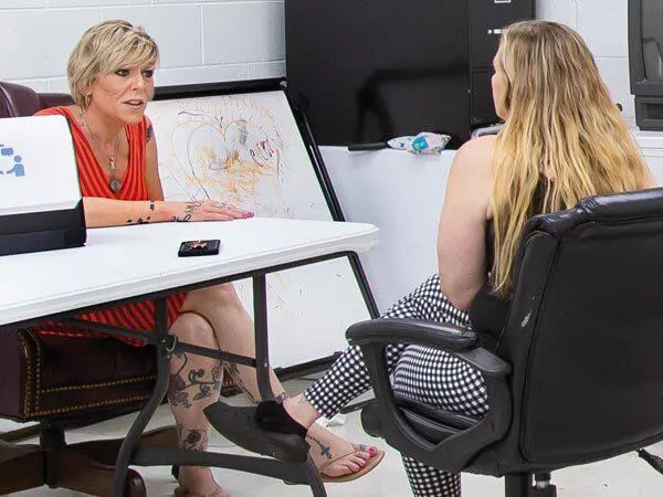 two women talk at table