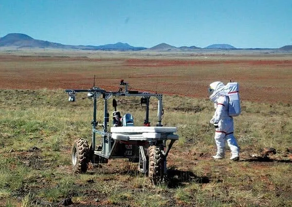 student helps test rover in desert