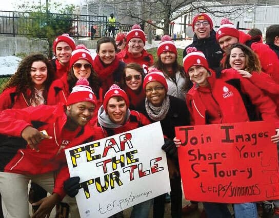 group wearing red and holding posters that read, "Fear the Turtle" and "Join Images. Share your s-tour-y"