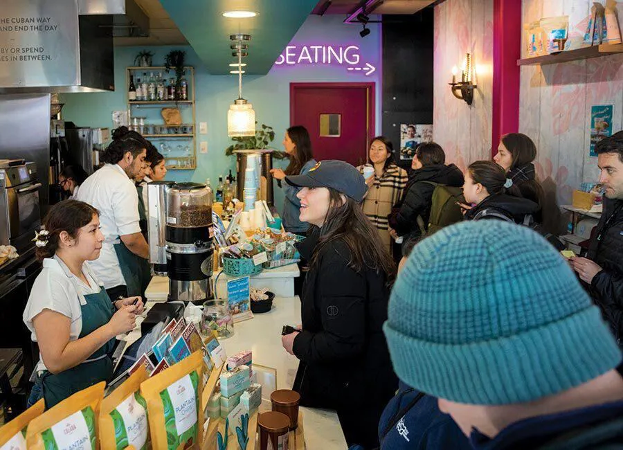 people wait at counter at busy restaurant