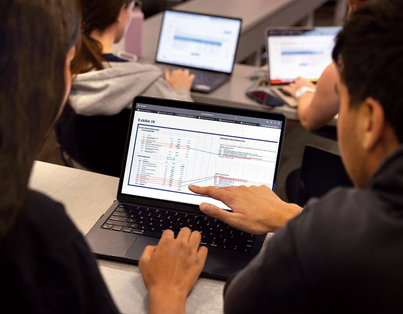 students analyze spreadsheet on laptop