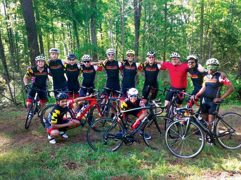 UMD cycling team poses with bikes on wooded trail